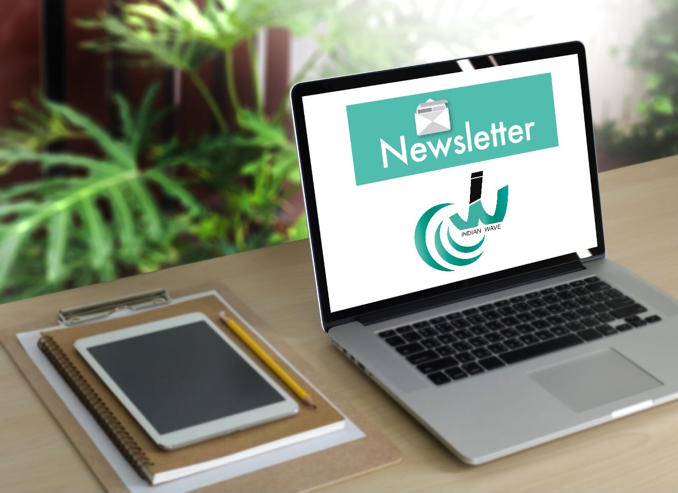 abonnement à la newsletter un laptop avec le mot newsletter et le logo d'Indian Wave en fond d'écran sur un bureau